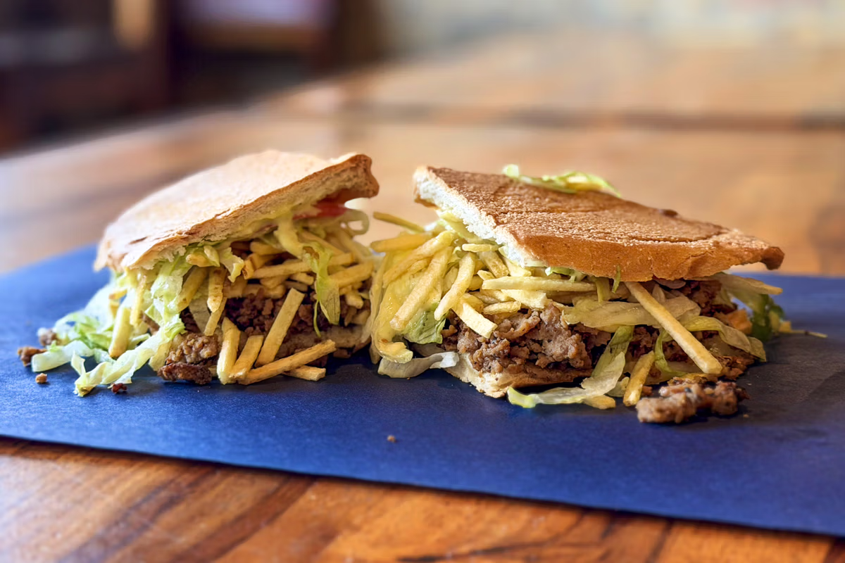 El Cubanito Steak sandwich with seasoned steak, lettuce, tomato, cheese, and shoestring potatoes in Chicago.
